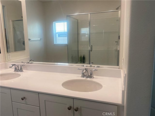 bathroom featuring vanity and a shower with door