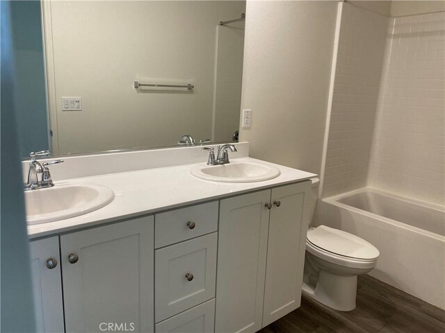 full bathroom featuring shower / bathing tub combination, hardwood / wood-style floors, vanity, and toilet