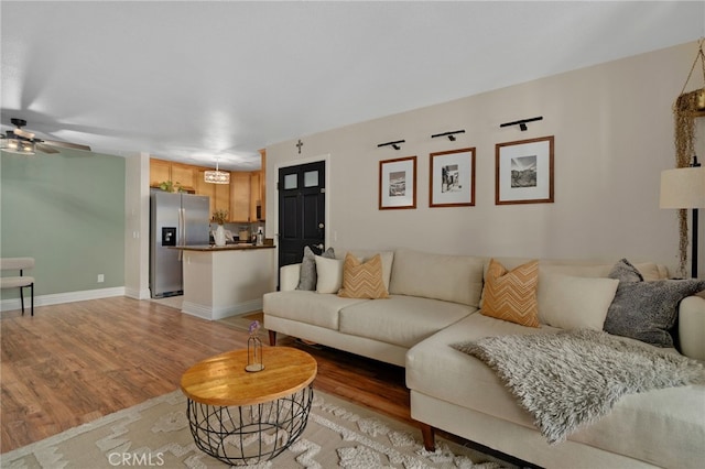 living room with ceiling fan and light wood-type flooring