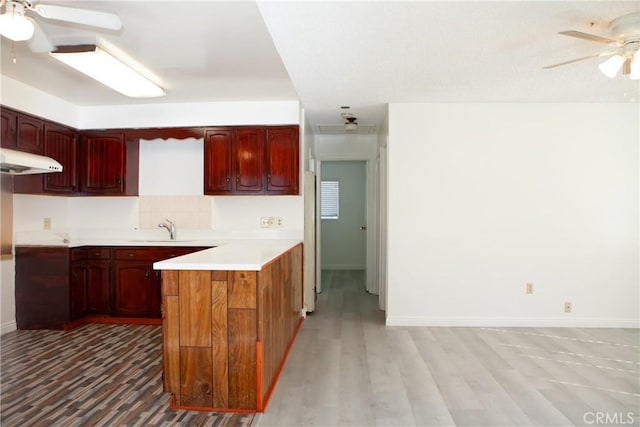 kitchen with ceiling fan, sink, light hardwood / wood-style flooring, backsplash, and kitchen peninsula