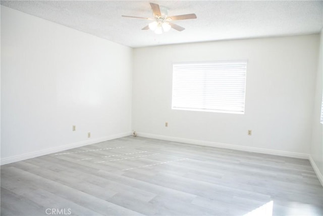 unfurnished room featuring ceiling fan, light wood-type flooring, and a textured ceiling