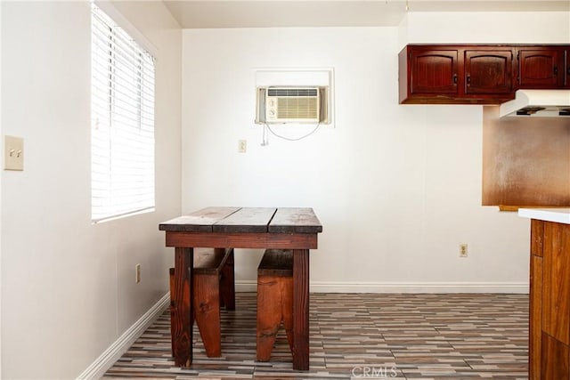 dining space featuring a wall mounted air conditioner and dark hardwood / wood-style floors