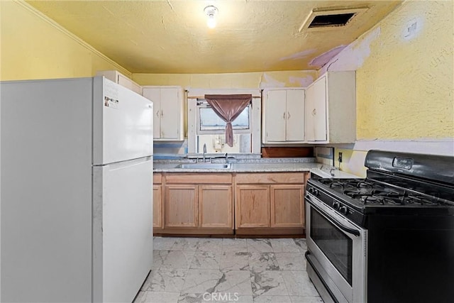 kitchen featuring sink, white refrigerator, ornamental molding, and stainless steel gas range