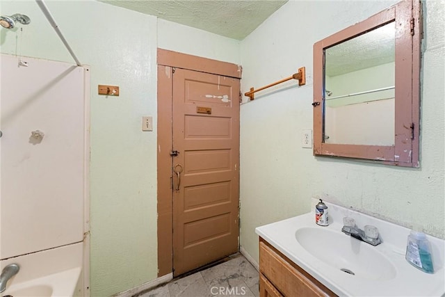 bathroom featuring shower / bathing tub combination, vanity, and a textured ceiling