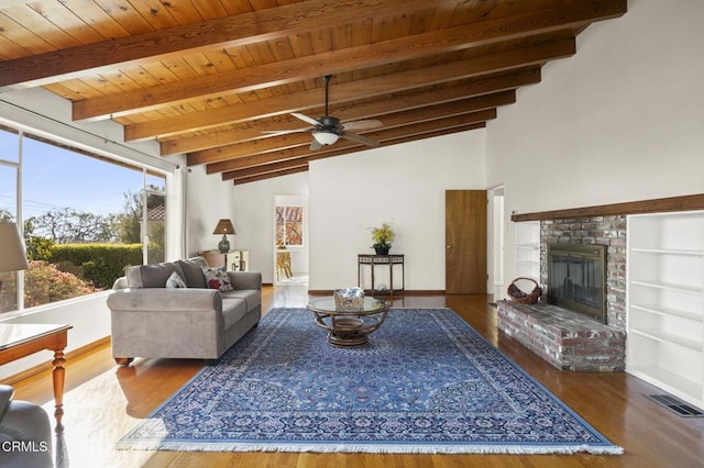 living room with a brick fireplace, ceiling fan, lofted ceiling with beams, and hardwood / wood-style flooring