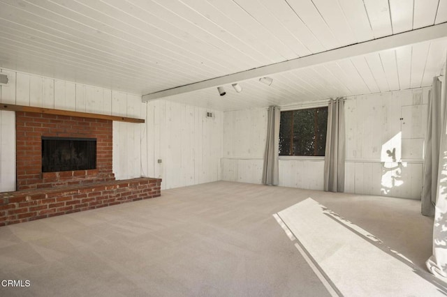 unfurnished living room featuring carpet flooring, a brick fireplace, and beamed ceiling