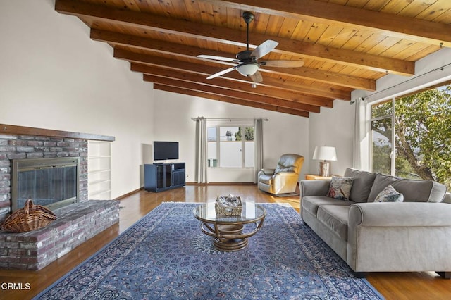 living room featuring ceiling fan, wood-type flooring, lofted ceiling with beams, wooden ceiling, and a fireplace