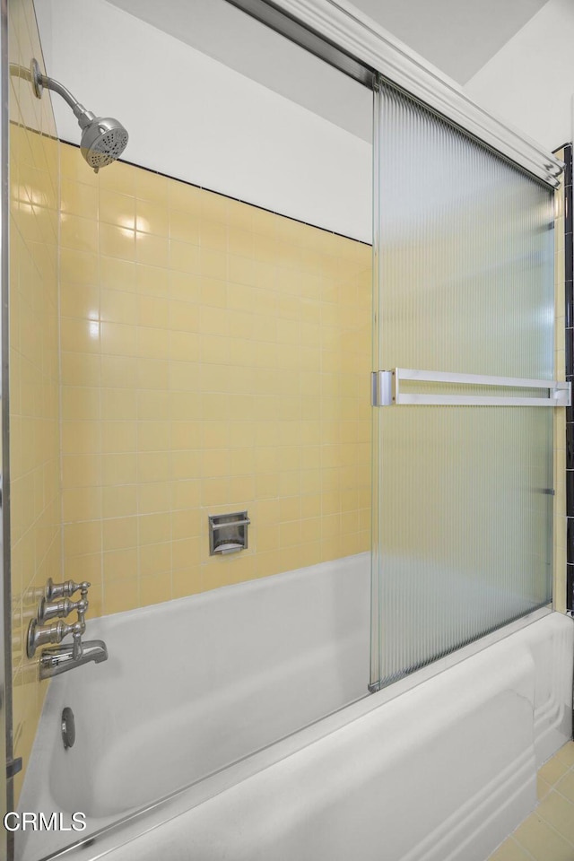 bathroom featuring combined bath / shower with glass door and tile patterned flooring