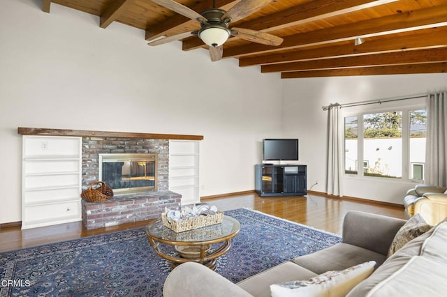 living room featuring wooden ceiling, hardwood / wood-style flooring, vaulted ceiling with beams, ceiling fan, and a fireplace