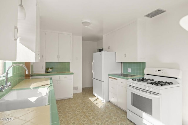 kitchen featuring pendant lighting, white appliances, sink, decorative backsplash, and white cabinetry