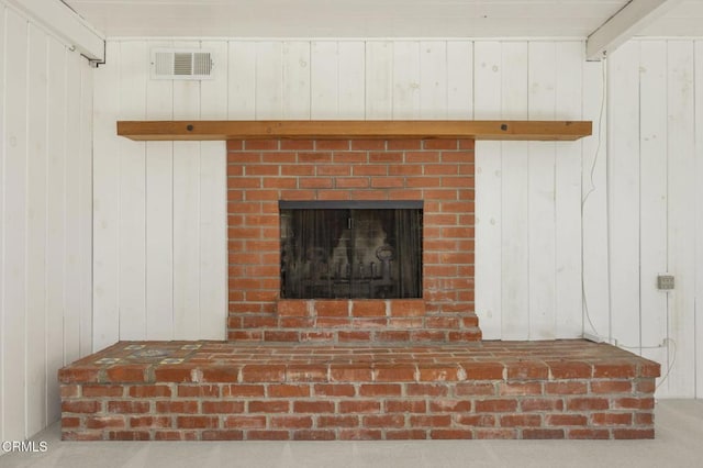 interior details featuring a fireplace and wooden walls