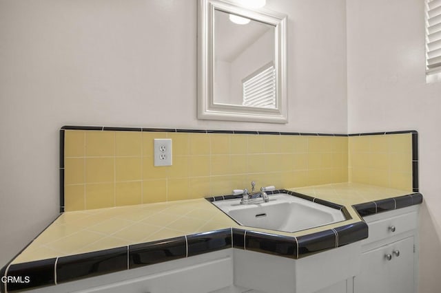 bathroom featuring decorative backsplash and a sink