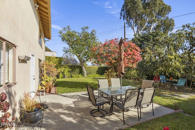 view of patio featuring outdoor dining area and fence