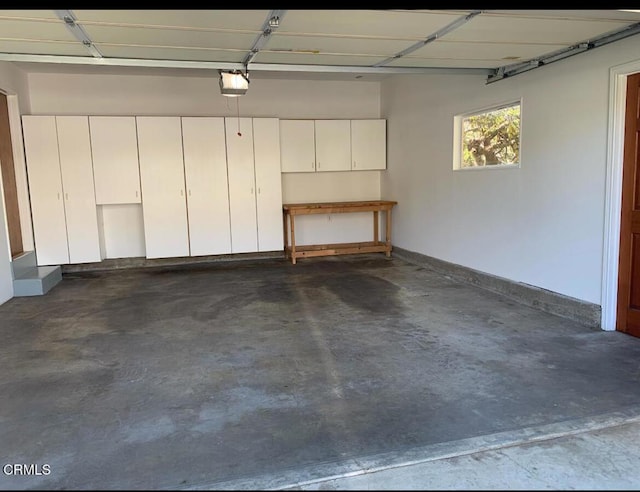 garage featuring a garage door opener and baseboards