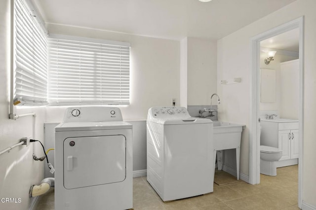 washroom featuring a sink, laundry area, and washer and dryer