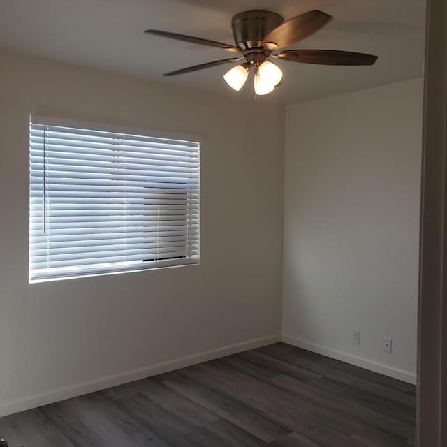 spare room with dark hardwood / wood-style floors and ceiling fan