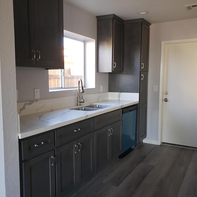 kitchen featuring dishwasher, dark hardwood / wood-style flooring, light stone counters, and sink