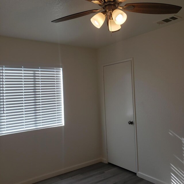 unfurnished room with dark hardwood / wood-style flooring and ceiling fan