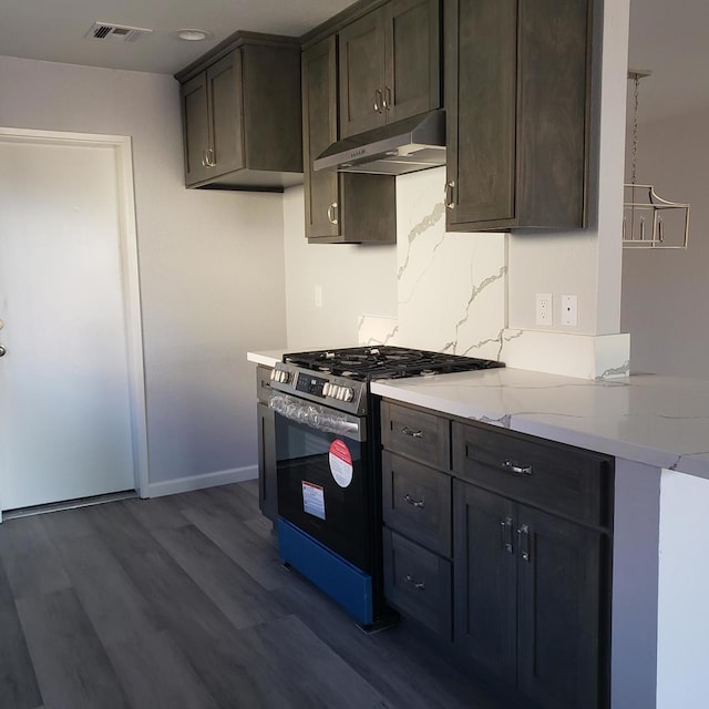 kitchen with light stone countertops, tasteful backsplash, dark brown cabinetry, stainless steel stove, and dark hardwood / wood-style floors