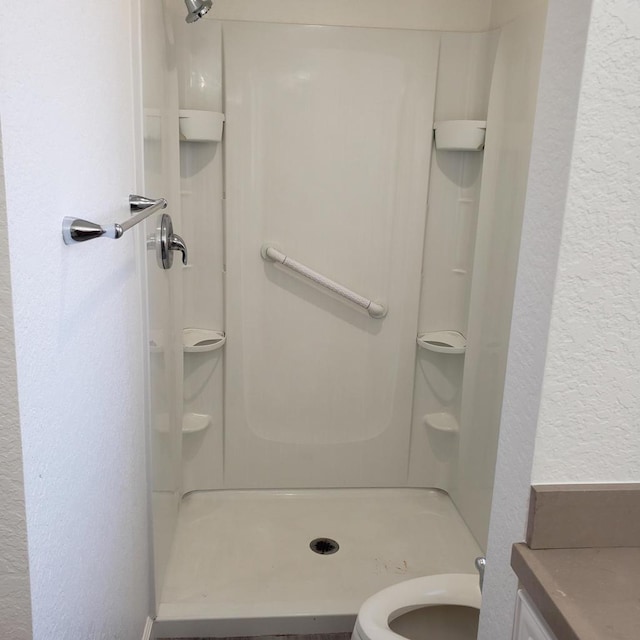 bathroom featuring a shower and toilet