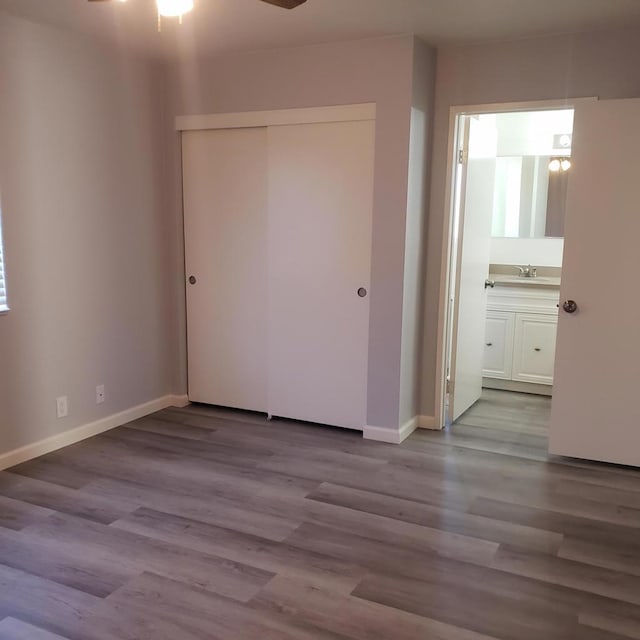 empty room with light hardwood / wood-style floors, ceiling fan, and sink