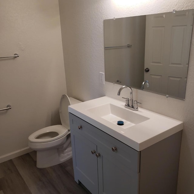 bathroom featuring hardwood / wood-style flooring, vanity, and toilet