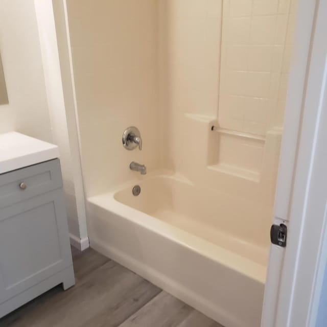 bathroom with vanity, shower / bathing tub combination, and hardwood / wood-style flooring