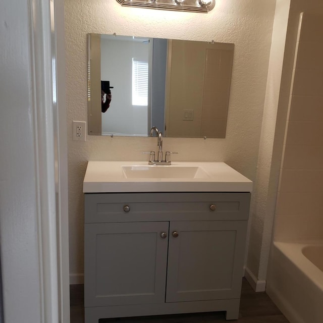 bathroom with vanity and a bath