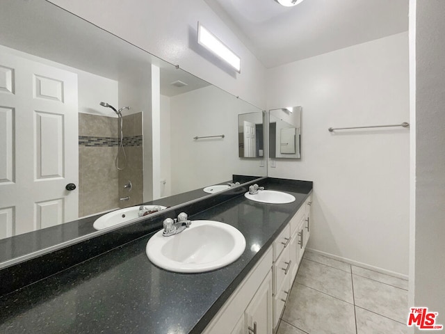 bathroom featuring tile patterned flooring, vanity, and tiled shower / bath