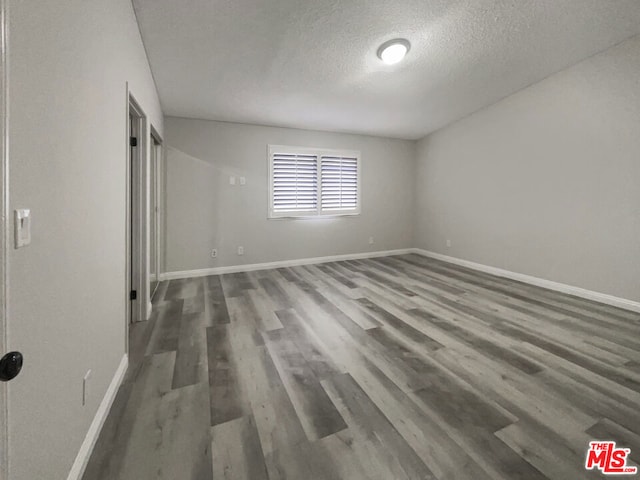 empty room featuring dark hardwood / wood-style flooring and a textured ceiling