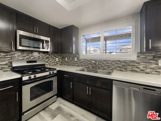 kitchen featuring decorative backsplash, appliances with stainless steel finishes, and sink