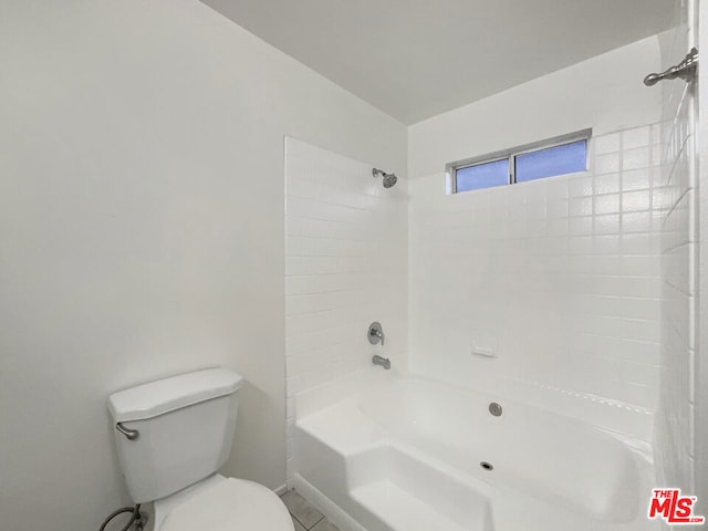 bathroom featuring toilet and tiled shower / bath