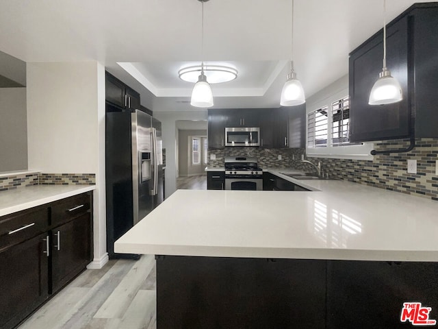 kitchen featuring appliances with stainless steel finishes, tasteful backsplash, hanging light fixtures, and sink