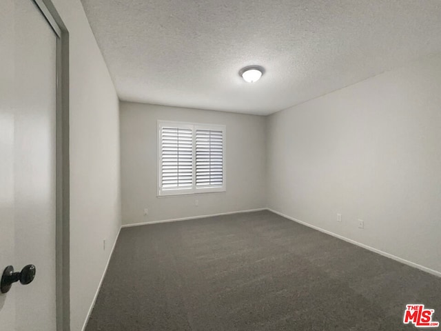 carpeted spare room with a textured ceiling