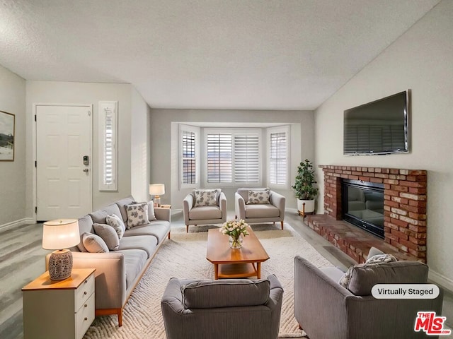 living room featuring carpet floors, a textured ceiling, and a brick fireplace