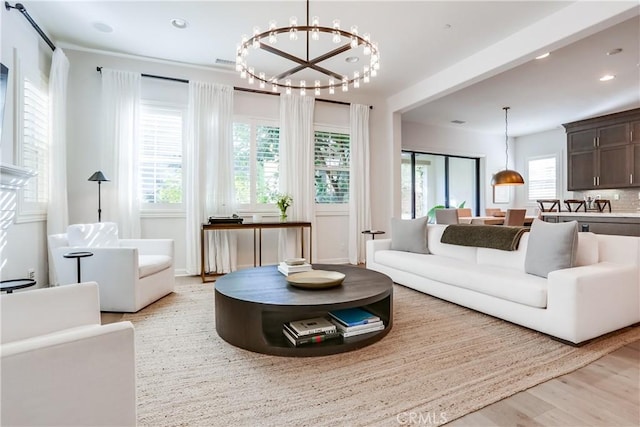 living room featuring light hardwood / wood-style flooring and an inviting chandelier