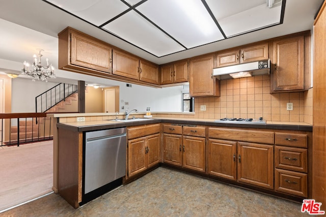 kitchen with sink, an inviting chandelier, stainless steel dishwasher, kitchen peninsula, and decorative backsplash