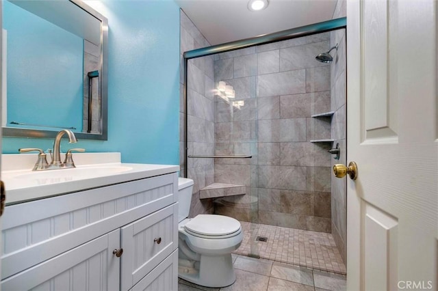 bathroom with tile patterned flooring, vanity, toilet, and a shower with shower door