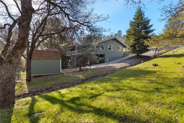 view of yard featuring an outdoor structure, a storage unit, and fence