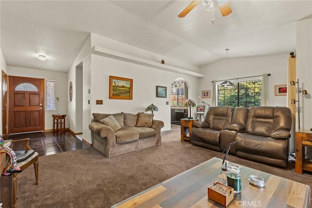 living room featuring dark tile patterned flooring, lofted ceiling, a ceiling fan, dark colored carpet, and baseboards