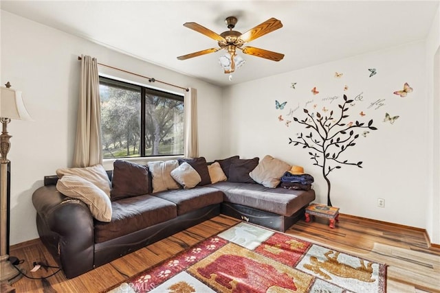 living area featuring ceiling fan, baseboards, and wood finished floors