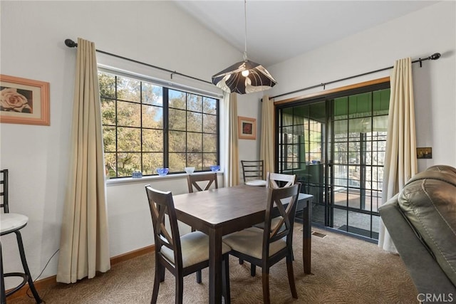 dining room with a wealth of natural light, visible vents, carpet floors, and lofted ceiling