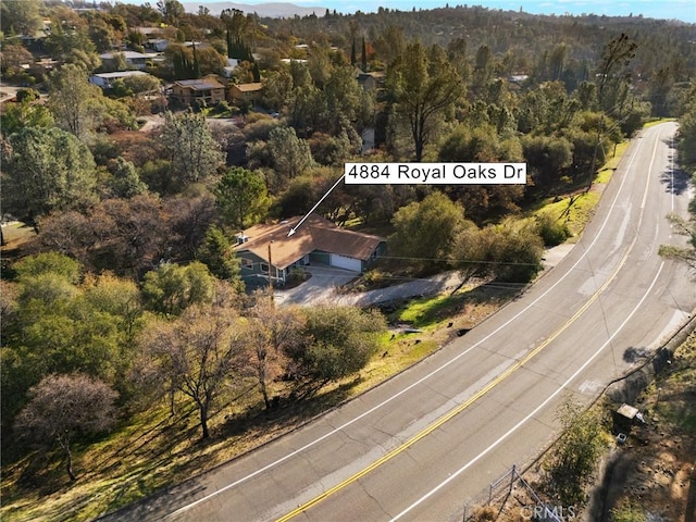 drone / aerial view featuring a wooded view