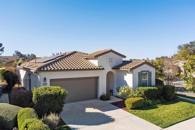 mediterranean / spanish house featuring a garage and solar panels