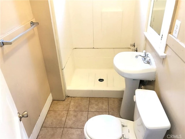 bathroom with tile patterned floors, toilet, and walk in shower