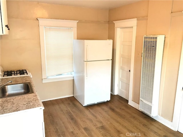 kitchen featuring white cabinets, dark hardwood / wood-style floors, white appliances, and sink