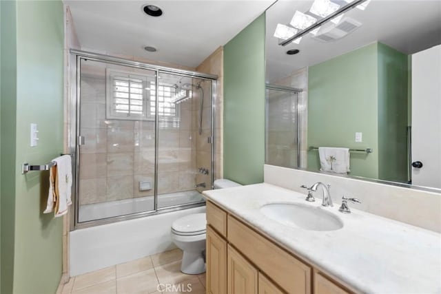 full bathroom featuring enclosed tub / shower combo, tile patterned floors, vanity, and toilet