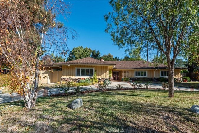 single story home with a front yard and a patio