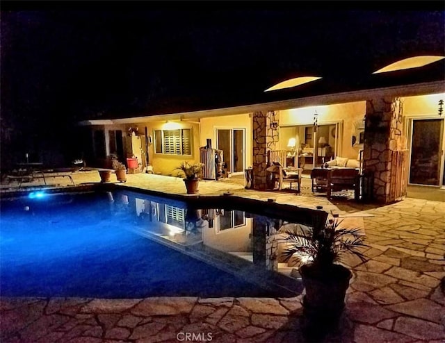 pool at twilight featuring a patio