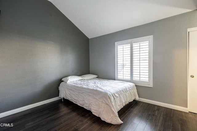 bedroom with dark wood-type flooring and lofted ceiling